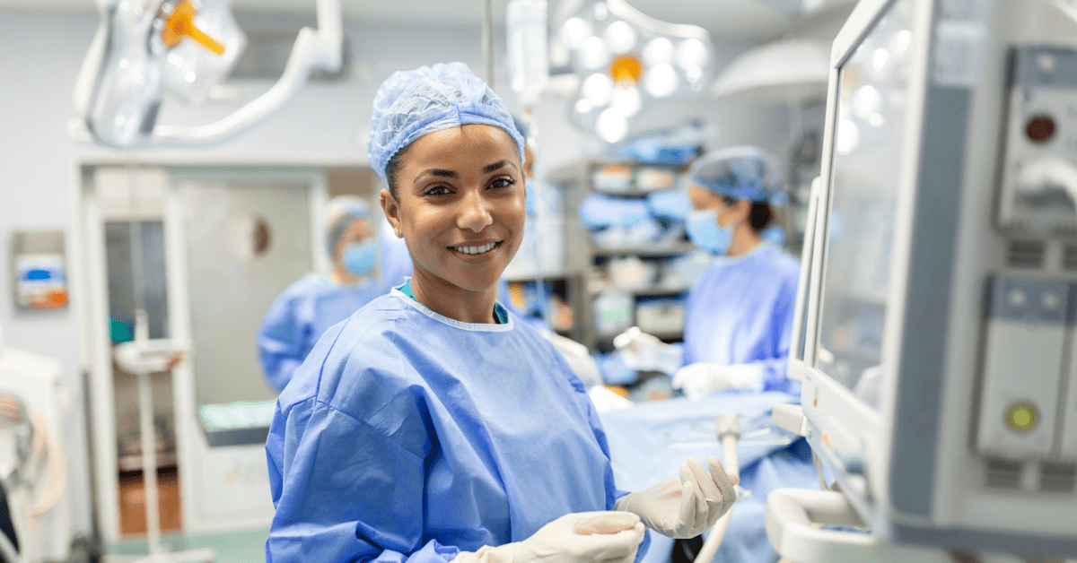 Anesthesiologist checking monitors while sedating patient before surgical procedure in hospital operating room. Young adult female African American patient is asleep on the operating table during surgery. Photo by: Getty Images/stock photo.