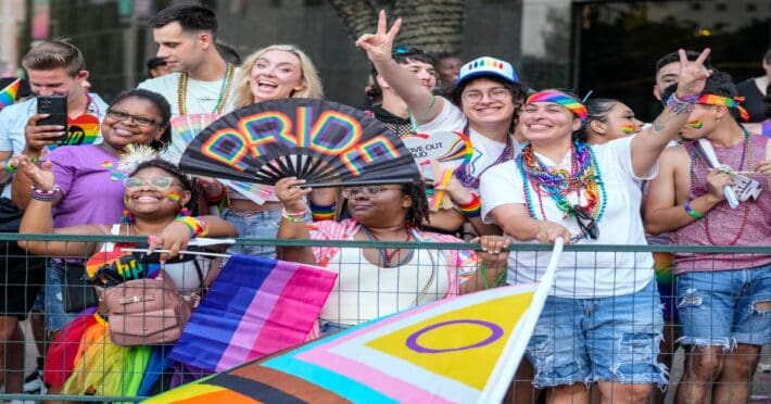 People along the parade route cheer as floats go by during the Houston Pride Parade downtown