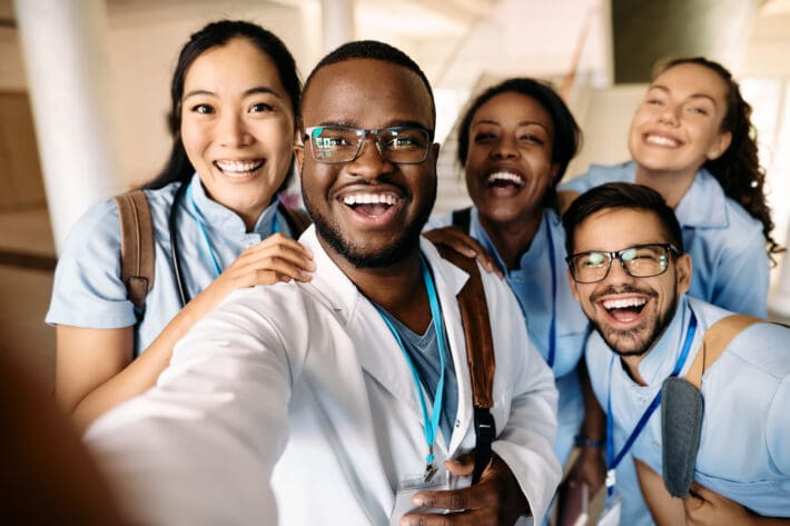 Multi-ethnic group of happy nursing students having fun while taking selfie at university.