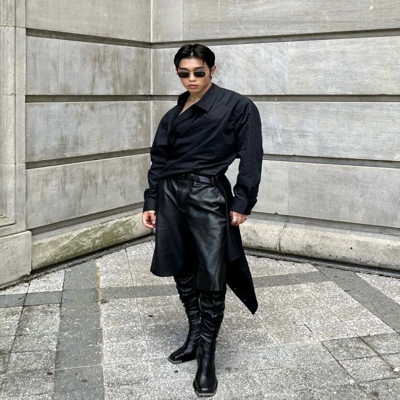 queer asian man in all black with black leather boots 
