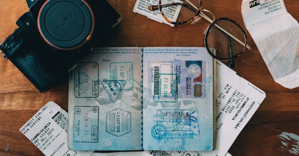 travel visa, glasses, camera and airline tickets