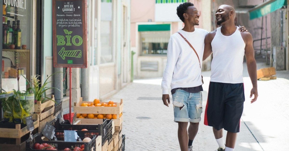 Two smiling men walking down a street