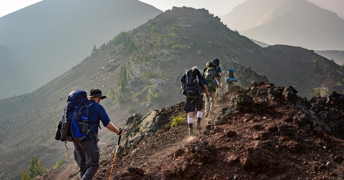 group of people hike up a mountain