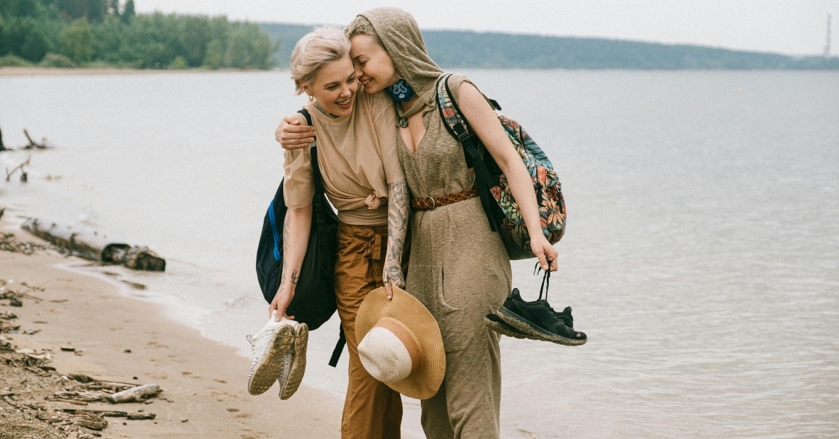 lesbian couple walking along the beach