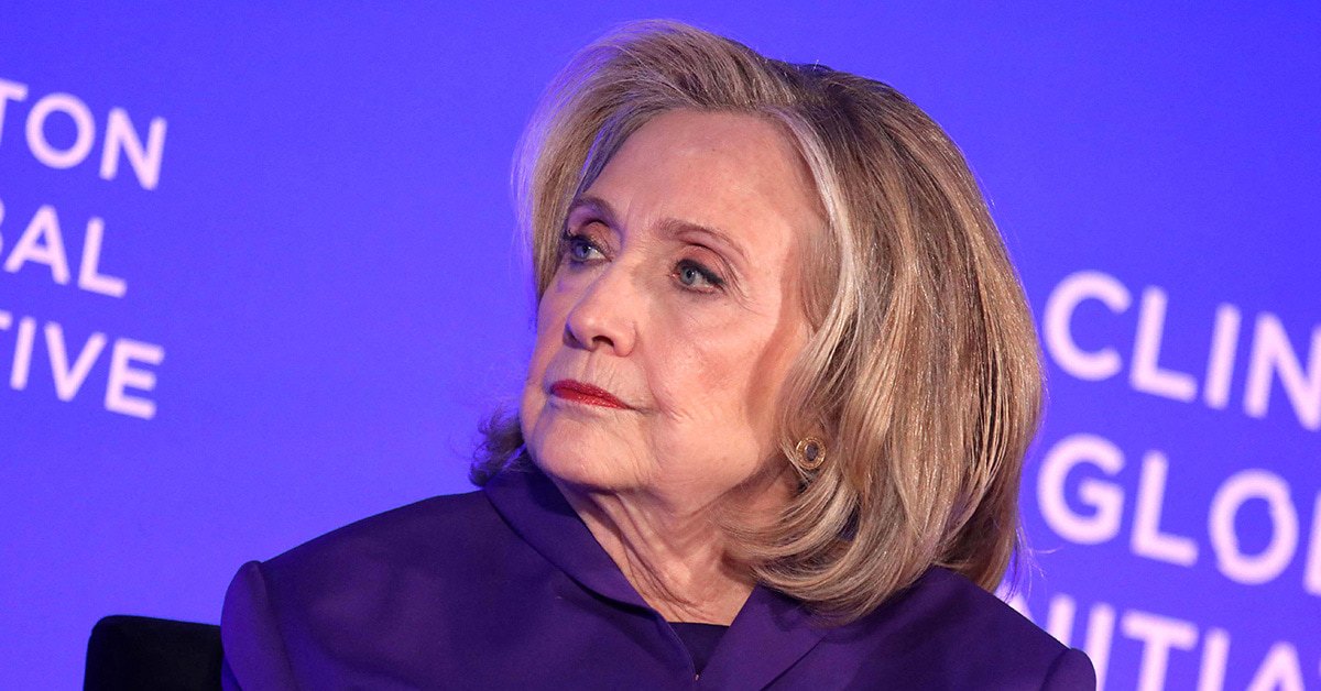 Hillary Clinton looking to the left in front of a Clinton Global Initiative background