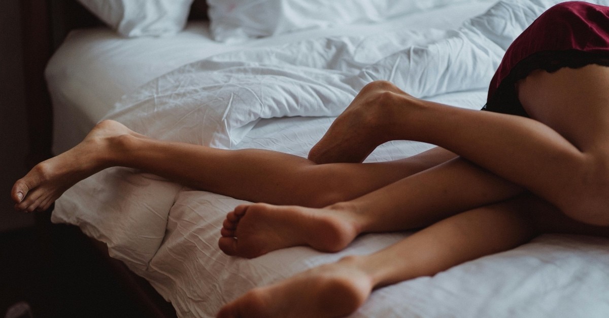 Couple's legs entwined in bed