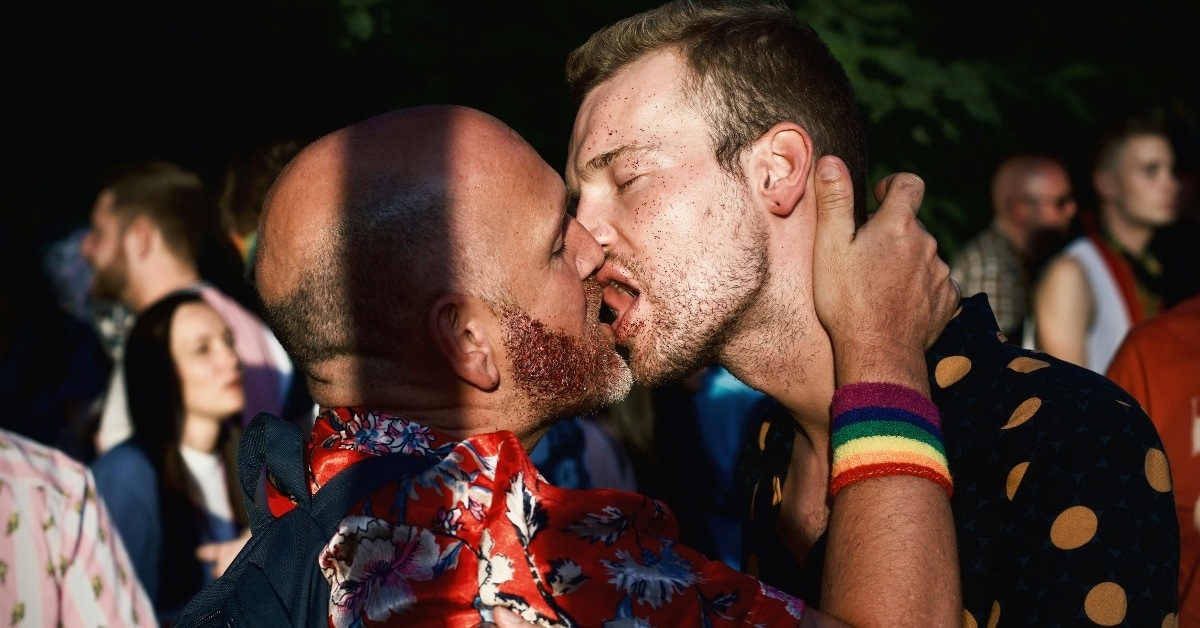 two individuals tongue-kissing in a crowd