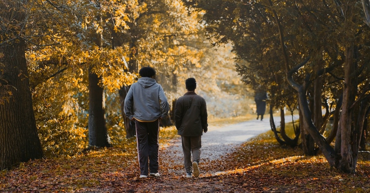 Two people walking on a path.