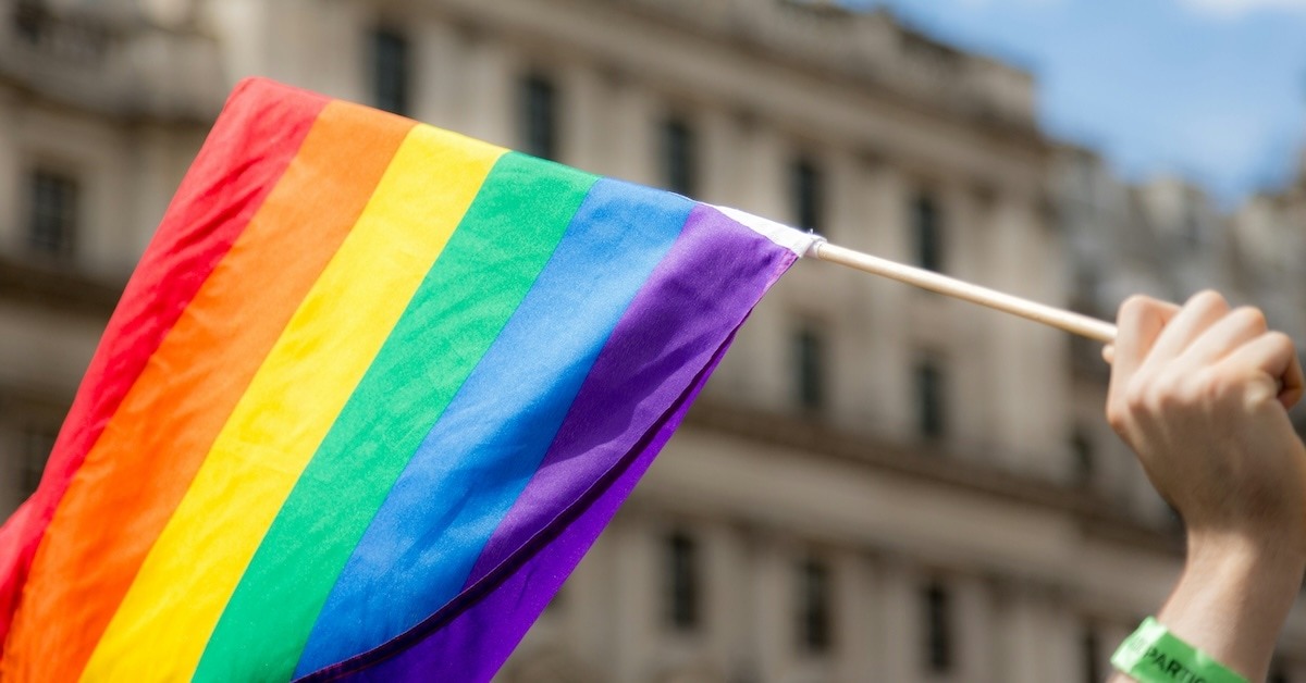 A hand holding a pride flag. 