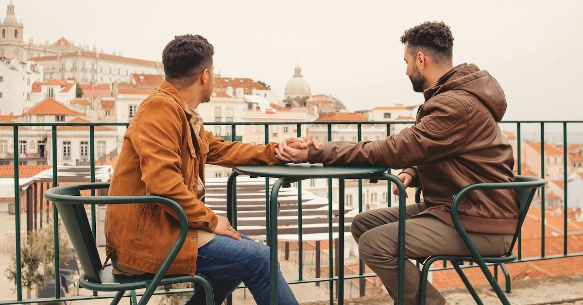 Two people holding hands at a table. 