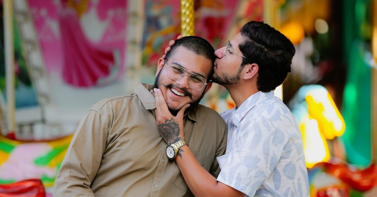 One person kissing another person on the forehead.