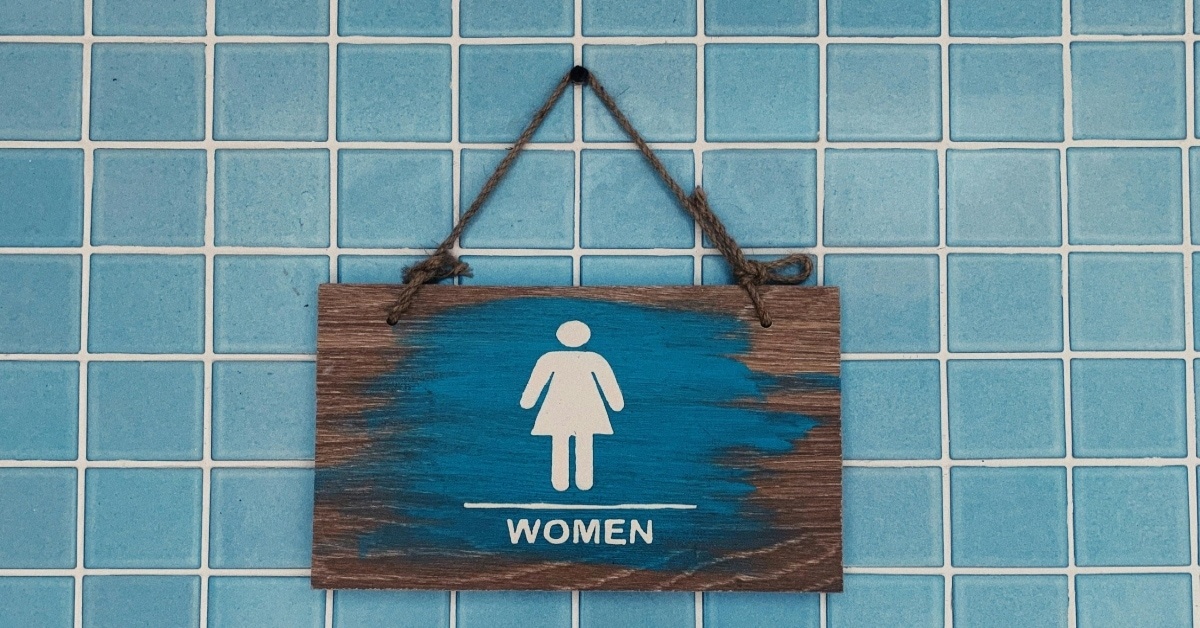 public bathroom sign on blue tiled wall