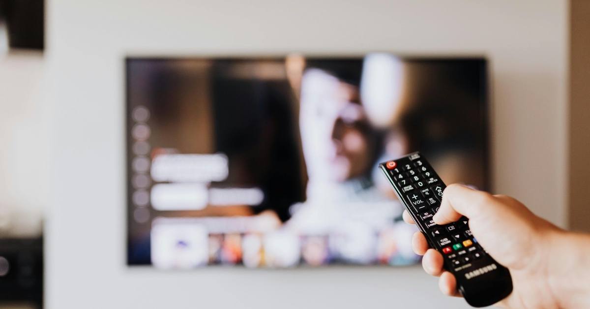 Person Pressing the Button of a Remote Control