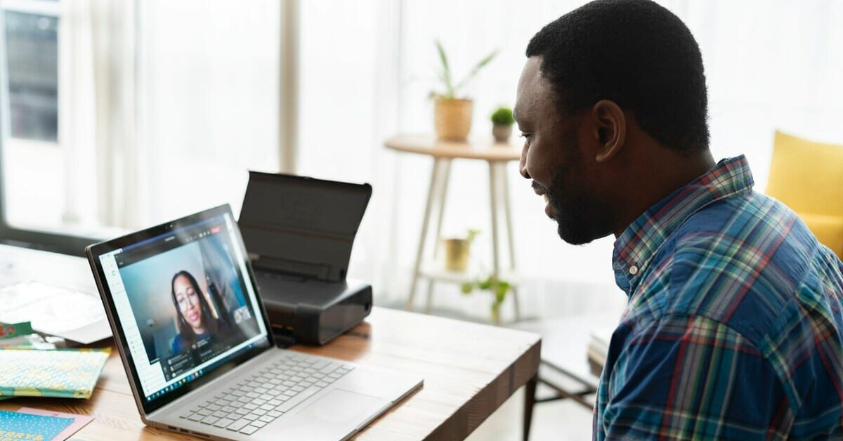 man in blue and white plaid dress shirt using macbook pro